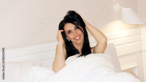 Beautiful brunette woman relaxation in bed with white blanket,retro 90s lifestyle photography