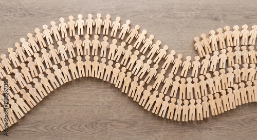 Flat wooden people cutouts arranged in wave photo for crowd community and society