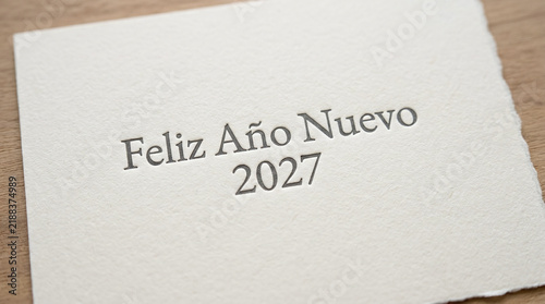 Minimalist feliz ano nuevo 2027 text on textured cream paper with paper texture