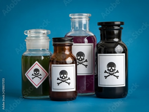 Group of chemical hazard bottles with skull and crossbones labels in studio setting