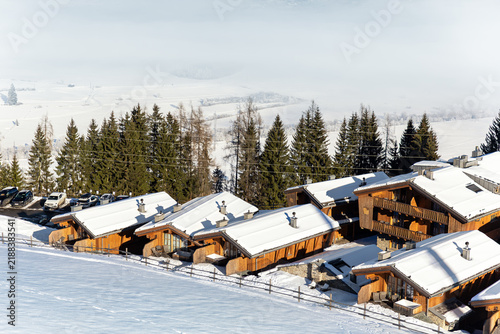 Cuadro en lienzo Snow-covered wooden chalets overlook foggy Zell am See Kaprun valley, surrounded by alpine forest and bright winter slopes