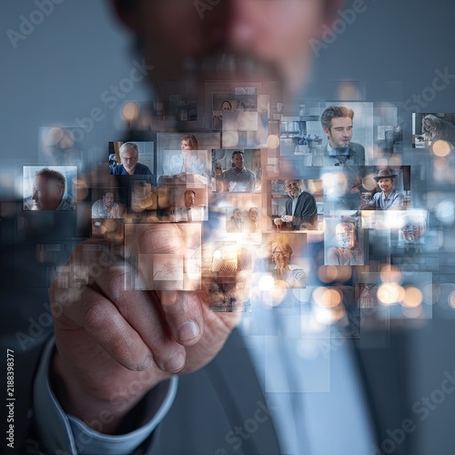 Businessman Interacting with Digital Photo Gallery of Diverse People in Modern Office Setting