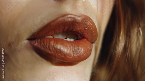 Close up of a woman with glossy brown lips and soft skin, beauty makeup detail, lip gloss cosmetics concept, sensual fashion portrait.