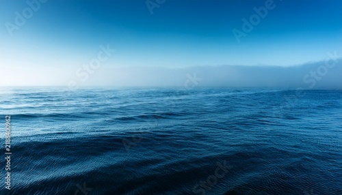 Calm Tranquil Blue Sea With No Waves And With Foggy Backgroudn