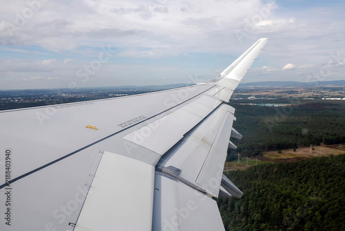 Bild auf Leinwand Airplane Wing With Extended Flaps During landing Roll Over Runway At Airport