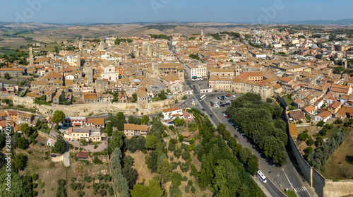 Фотография Panorama of Tarquinia, in the province of Viterbo, in Lazio, Central Italy, with the rooftops of the town, the stone walls of the historic center and the cultivated fields of the countryside