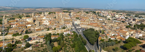 Картината върху платно Panorama of Tarquinia, in the province of Viterbo, in Lazio, Central Italy, with the rooftops of the town, the stone walls of the historic center and the cultivated fields of the countryside