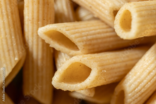 Принти на полотні Extreme macro of uncooked whole wheat penne pasta showing tubular openings, rough edges and detailed ridged surface