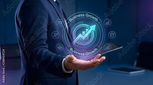 A business person holding a glowing holographic interface with digital data and futuristic network icons