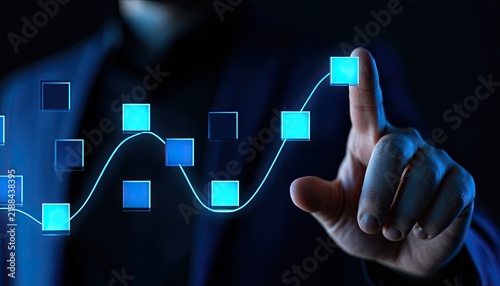 Finger interacts with glowing blue digital squares forming a rising graph