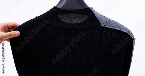 Fotografie A semi-sheer knit top hanging on a hanger, showcasing the neckline details