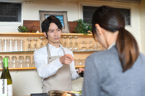 Fotografie Angry Japanese Restaurant Manager Scolding Female Employee at Work
