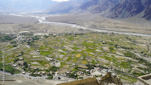 Fotografie Aerial view of green terraced fields in a mountainous valley with village settle