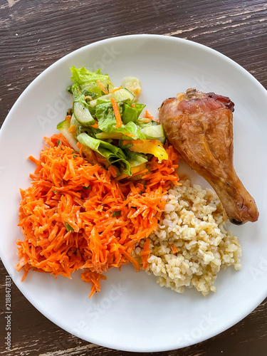 Top view of plate with balanced meal of bulgur, chicken, carrot salad and green salad, healthy eating and nutrition