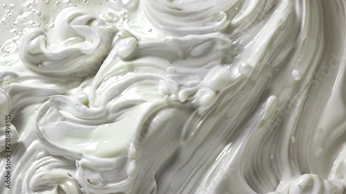 Glossy white cream swirling in smooth waves, thick dairy texture close up, clean minimal food background, luxurious cosmetic surface.