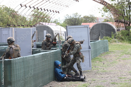Armed special forces soldiers in camouflage tactical gear during a tactical combat exercise or combat operation