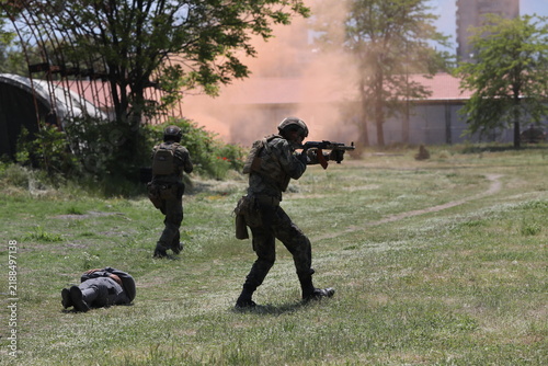 Armed special forces soldiers in camouflage tactical gear during a tactical combat exercise or combat operation
