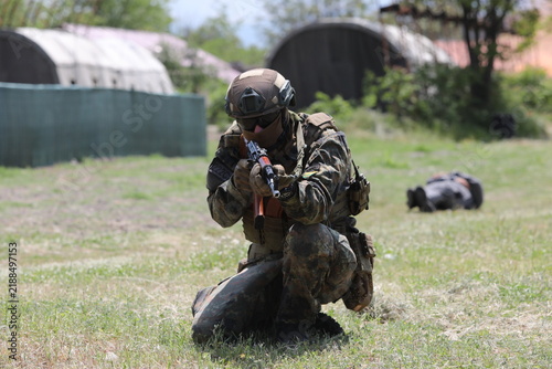 Armed special forces soldiers in camouflage tactical gear during a tactical combat exercise or combat operation