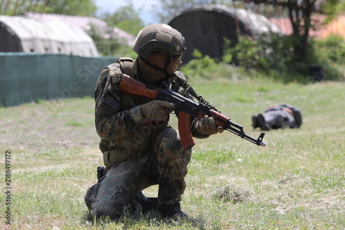 Armed special forces soldiers in camouflage tactical gear during a tactical combat exercise or combat operation