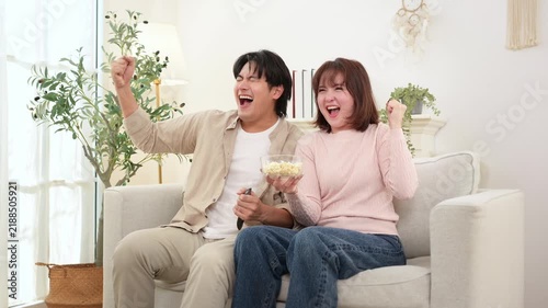 Couple Enjoys Movie Time at Home With Snacks and Laughter on a Cozy Sofa