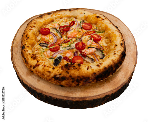Shrimp pizza with melted cheese, tomato, mushroom, red onion and chili on golden baked crust and wooden board, isolated cut out object on transparent background.