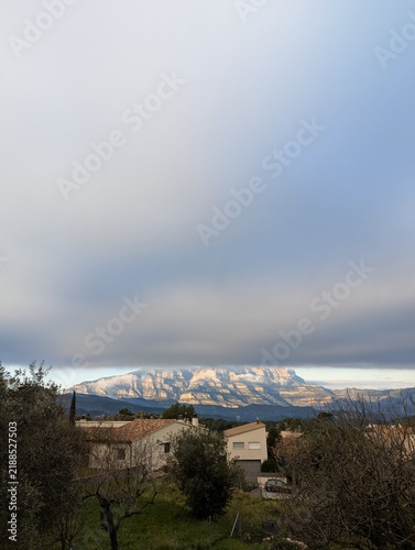 Distant mountain range under a heavy cloud layer above a rural landscape