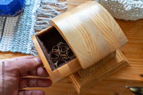 Man opens a hand made jewelry box with real gold rings with diamonds.