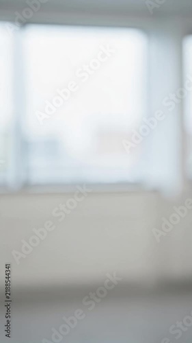Close-up shot of two business professionals in formal dark suits shaking hands firmly. Smooth, firm handshake motion in a bright, modern office setting. Soft natural light filtering through o