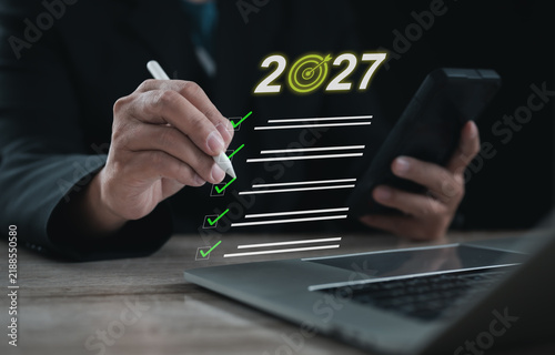 2027 business goals checklist with target symbol and completed tasks on virtual interface, representing annual planning, priorities, objectives, productivity, achievement and future strategy.