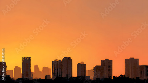 Silhouetted buildings under a warm sunset sky.