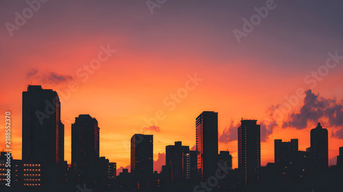 Silhouetted buildings under a warm sunset sky.