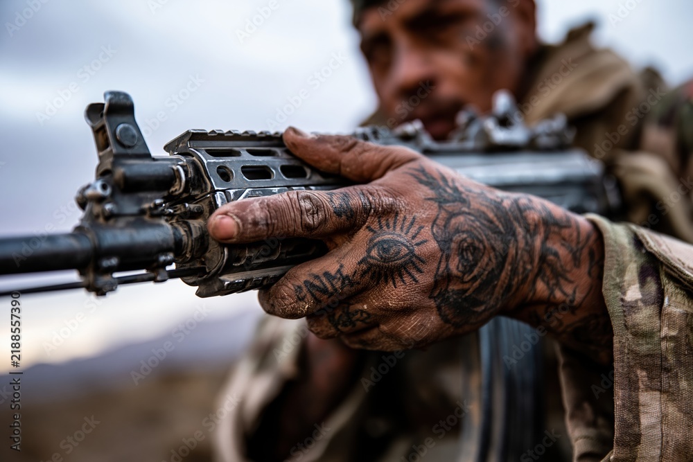Obraz premium Soldier Holding Rifle with Tattooed Hand
