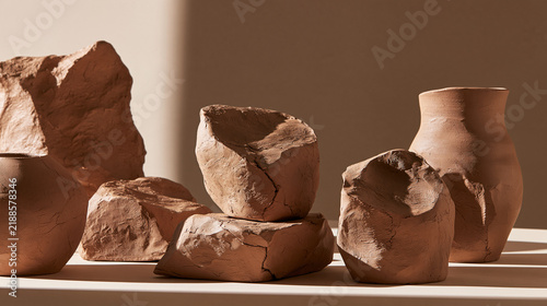 Handmade terracotta pottery and natural stone sculptures on beige background   