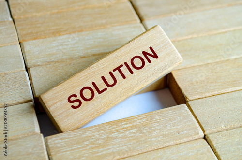 Close up view of solution text on wooden block representing problem solving related matters.