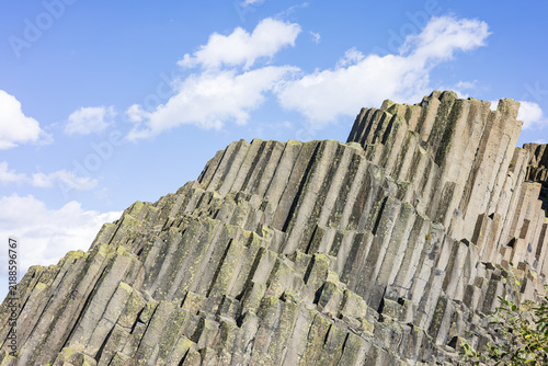 Panska Skala basalt columns rock formation under blue sky in Czech Republic.  Famous volcanic columnar basalt cliffs, majestic natural landmark in Europe.