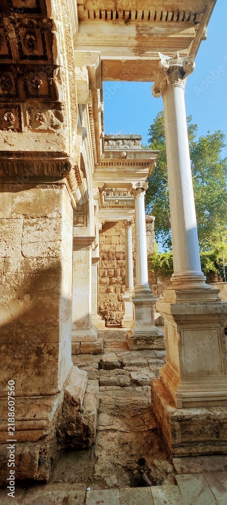 Fototapeta premium Side view of ancient Roman Hadrian's Gate in Antalya, Turkey. Close-up shot of historic marble architecture in Kaleici.
