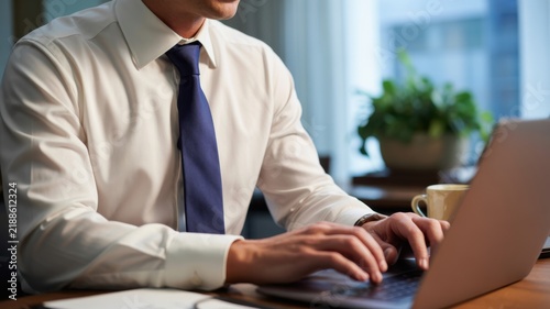 Professional Businessman Wearing White Shirt And Blue Tie Typing On Laptop Computer