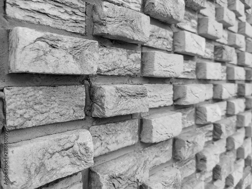 Textured background of grey brickwork wall with relief surface. Full frame. Design
