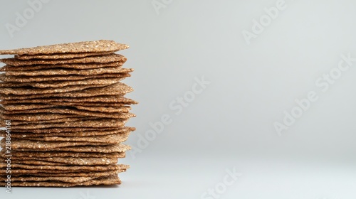 A beautifully arranged stack of whole-grain crackers captured against a clean white background showcasing their texture and quality