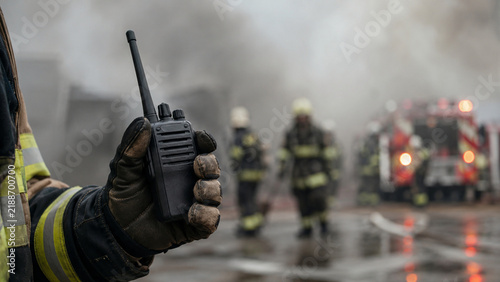 Close Up of Firefighter Holding Two Way Radio During Emergency Response Operation