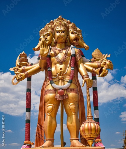 Photography Intricate Multi-Armed Hindu Deity Statue Against a Blue Sky