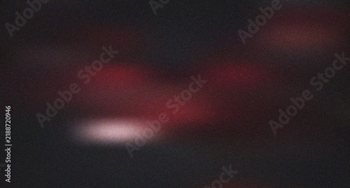 Foto Subtle reddish blurs with a luminous highlight on a dark grainy background creat