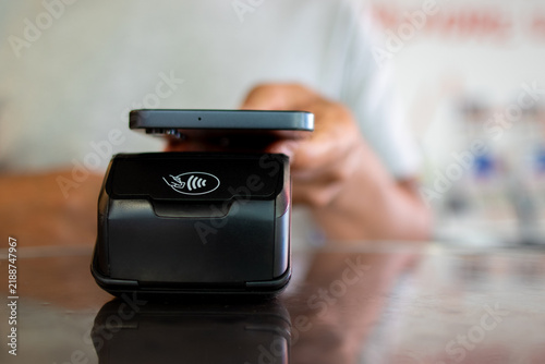 Customer making secure contactless payment using smartphone at retail point of sale terminal
