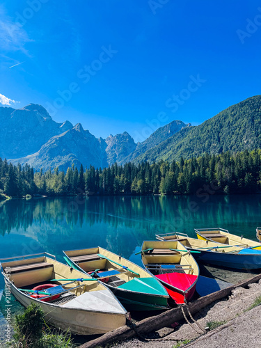 Quadro su tela Lago di Braies alpine lake with wooden boats, turquoise water surrounded by moun