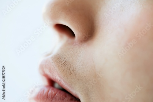 Macro side view of visible hair above a woman’s upper lip, representing unwanted facial hair, hormonal changes and cosmetic hair removal concerns in women
