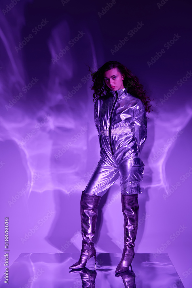 Fototapeta premium Futuristic fashion shines in neon hues with a chic young woman standing confidently