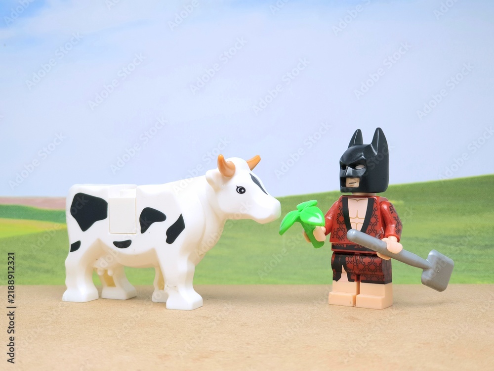 Obraz premium Indonesia - December 1, 2023 : Mini toy figure of people at table with blurred background. Miniature photography concept design. Farmer give green leaves plant.