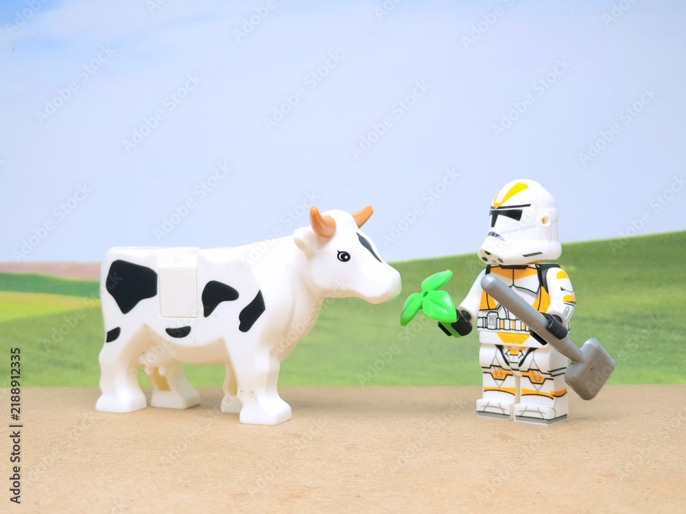 Obraz premium Indonesia - December 1, 2023 : Mini toy figure of people at table with blurred background. Miniature photography concept design. Farmer give green leaves plant.