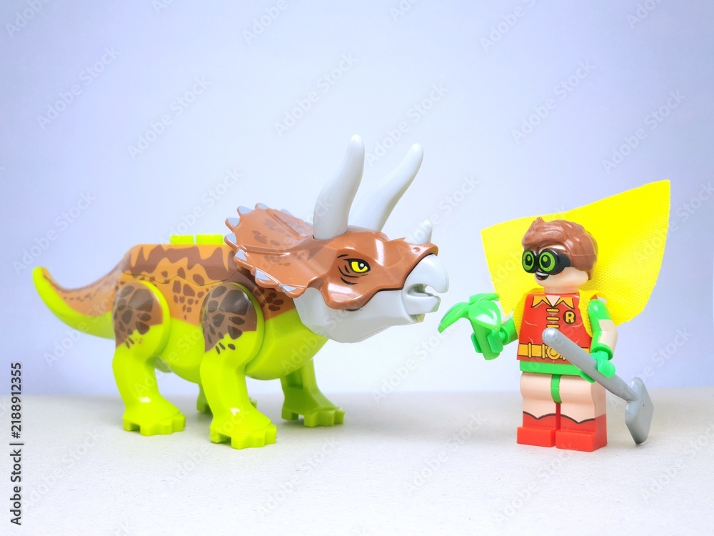 Obraz premium Indonesia - December 1, 2023 : Mini toy figure of people at table with blurred background. Miniature photography concept design. Farmer give green leaves plant.