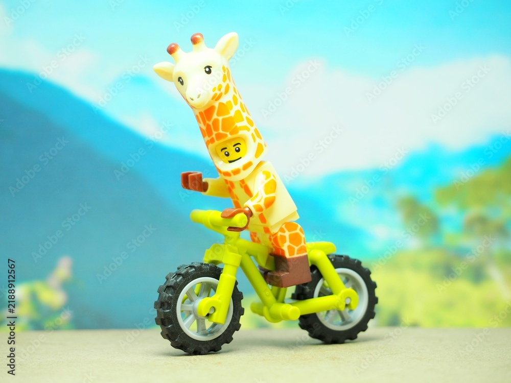 Obraz premium Indonesia - October 3, 2023 : Mini toy of action figure at table with blurred background. Toy photography concept. Riding the bicycle conceptual design.